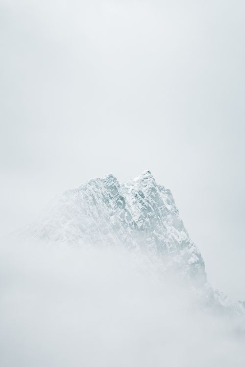 Free Serene view of a mist-covered mountain peak with snow, highlighting nature's beauty. Stock Photo