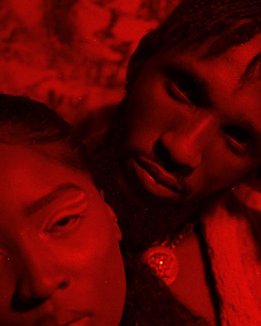 Close-up portrait of a couple with red lighting conveying love and intimacy.