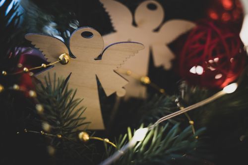 Free Close-up of a wooden angel ornament amidst festive Christmas decor, capturing a warm holiday spirit. Stock Photo