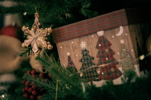 Free A close-up shot of a decorated holiday gift box and ornament hanging on a Christmas tree. Stock Photo