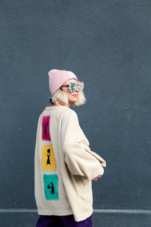 Woman in Beige Sweater Wearing Fashionable Eye Mask while Looking Afar