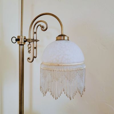 Vintage brass floor lamp with a beaded glass shade — photo by Em Hopper on Pexels