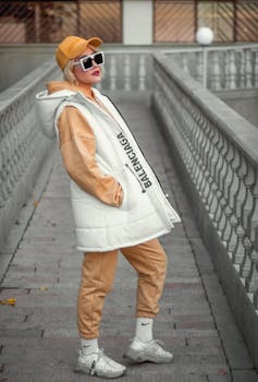 Stylish woman in urban setting wearing trendy street fashion with chic accessories and luxury branding in daylight.