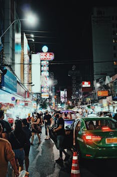 Vibrant night scene capturing a bustling street market with neon lights and city life.