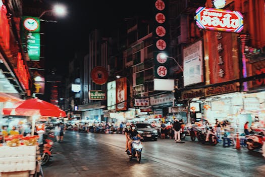 Explore the dynamic nightlife of an Asian city street bustling with neon lights and vibrant activity.
