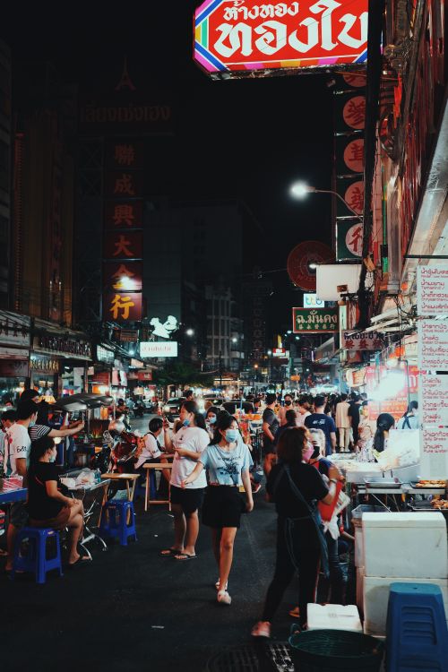 Free A vibrant night market scene with people dining and shopping under neon lights, reflecting urban culture. Stock Photo
