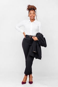 Portrait of a confident businesswoman in corporate attire posing in a studio with white background.