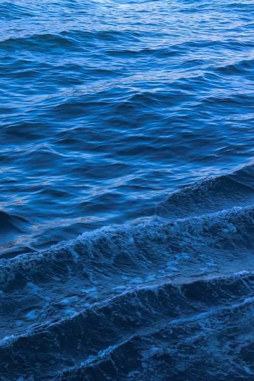 Free Close-up of serene blue ocean waves, capturing the natural beauty and tranquility of the sea. Stock Photo