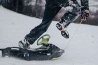Unrecognized Person Running and Pulling Sledge on Snowy Slope