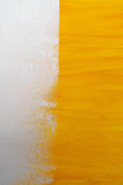 Abstract texture with a blend of white and yellow paint on a canvas.