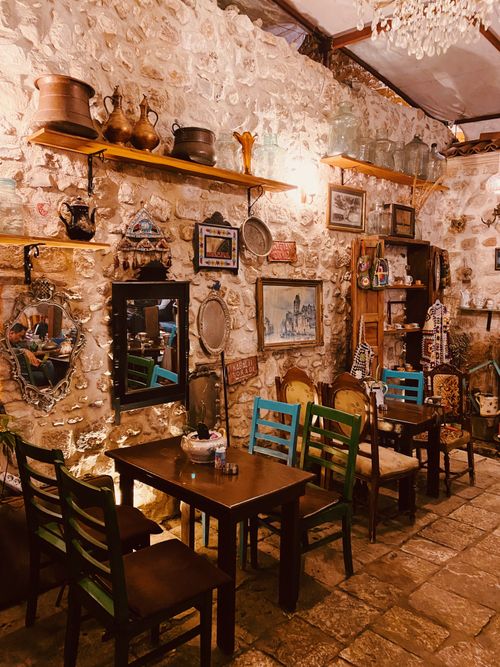 Free Charming vintage cafe interior with rustic stone walls and eclectic decor, creating a cozy atmosphere. Stock Photo