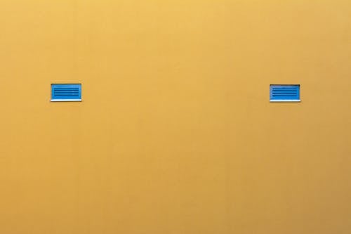 Free Blue Tiny Windows in a Yellow Wall  Stock Photo