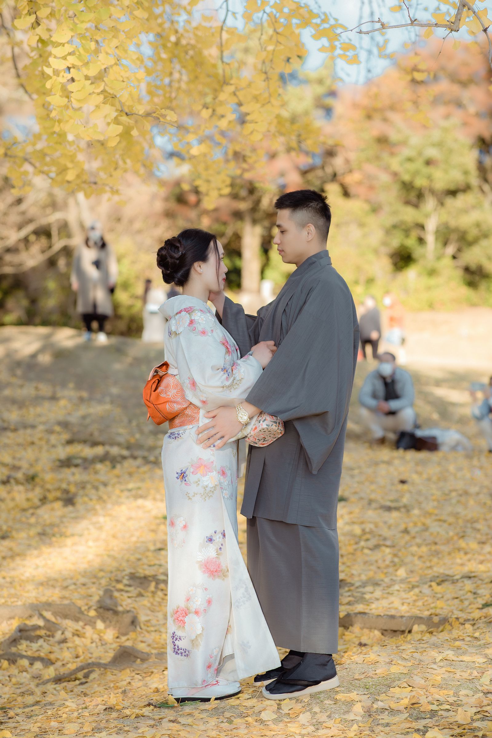 紅葉の中で寄り添う着物姿のカップル
