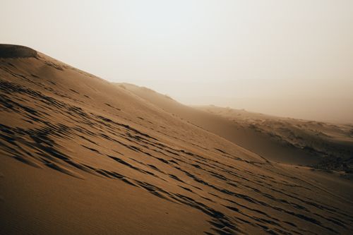 Free Tranquil desert sand dunes with ripple patterns at sunset, evoking a sense of calm and isolation. Stock Photo