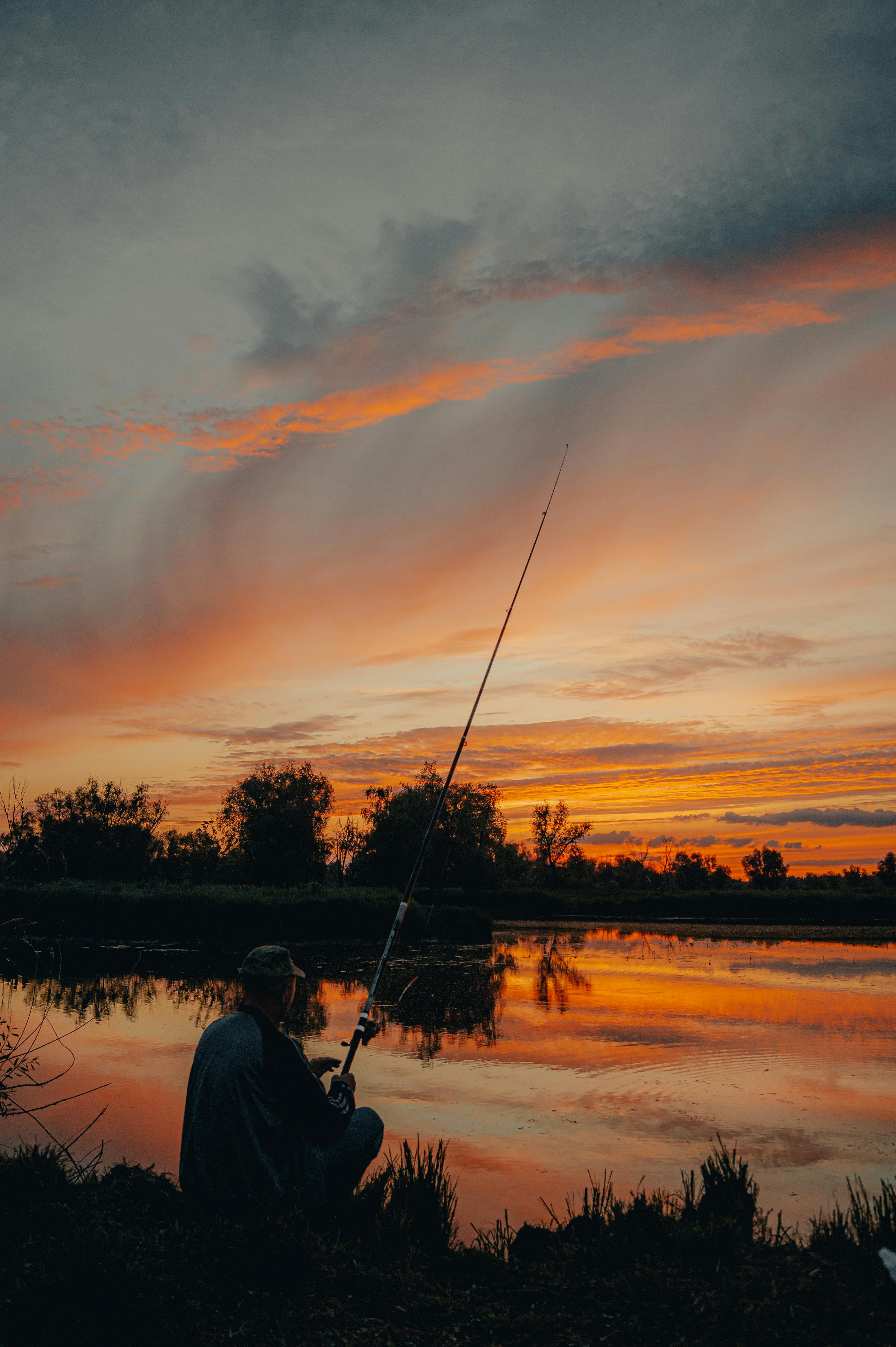 Photo of a Man Fishing During Sunset · Free Stock Photo