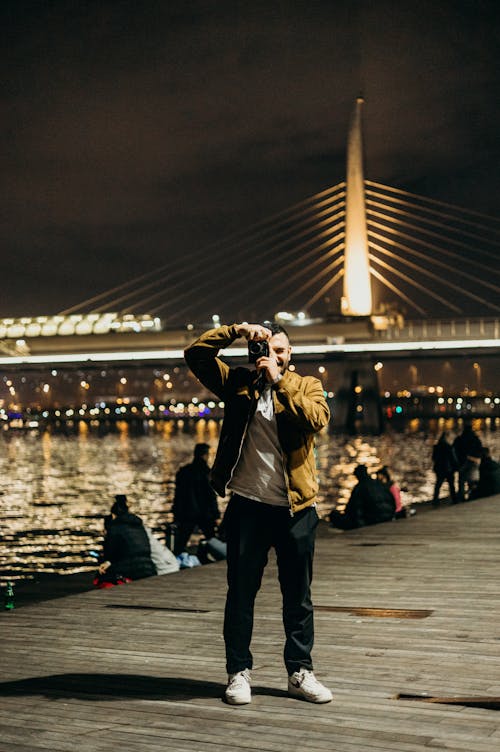 Free Photo of a Man Using a Camera During the Night Stock Photo