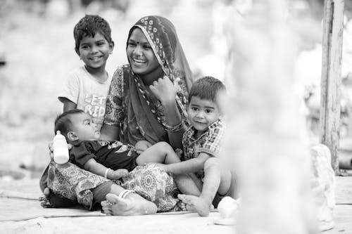 Monochrome Photo of a Mother and Her Children Smiling Together