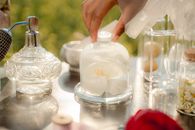 Hand Touching Glass Jar with Flower Inside