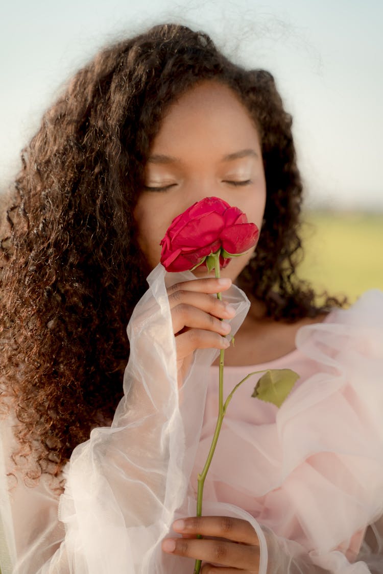 Woman In Tulle Dress Smelling Red Rose