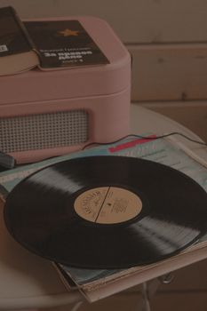A classic vinyl record player with a vinyl disc in a cozy retro setting.