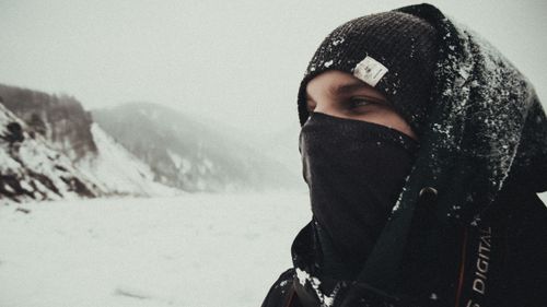 Free A person dressed for winter, standing in a snowy mountainous landscape, conveying a sense of adventure. Stock Photo