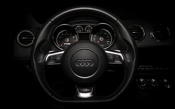 Close-up of an Audi car's dashboard and steering wheel, highlighting luxury design.