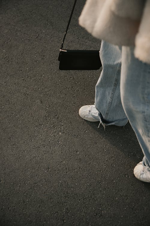 Person in Blue Denim Jeans and White Sneakers