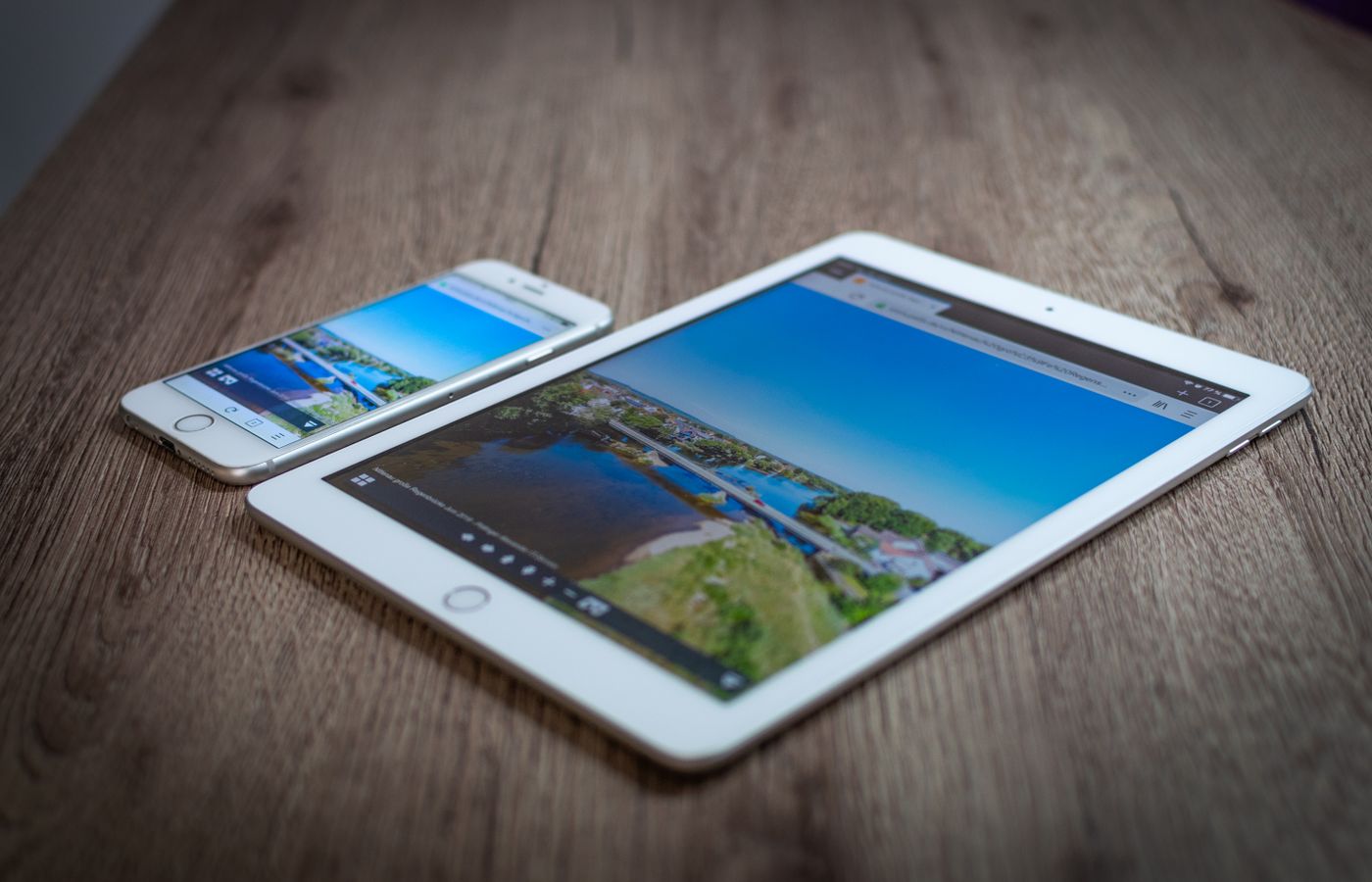 iPad and iPhone showing a scenic landscape on a wooden table, highlighting portability and technology.