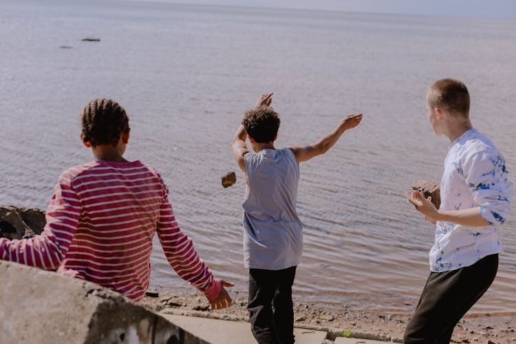 Teenagers Throwing Rocked At The River