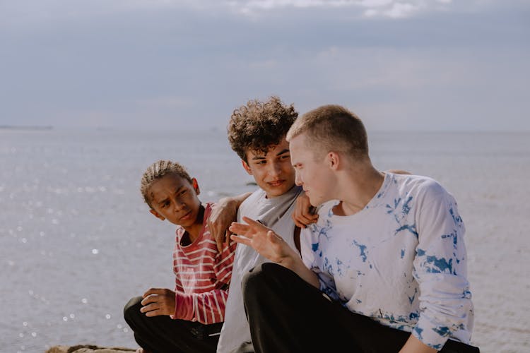 Group Of Teenagers Sitting On Seaside