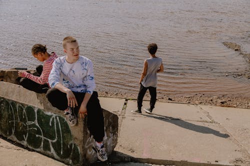 A Boy Wearing a White Sweater and Black Pants