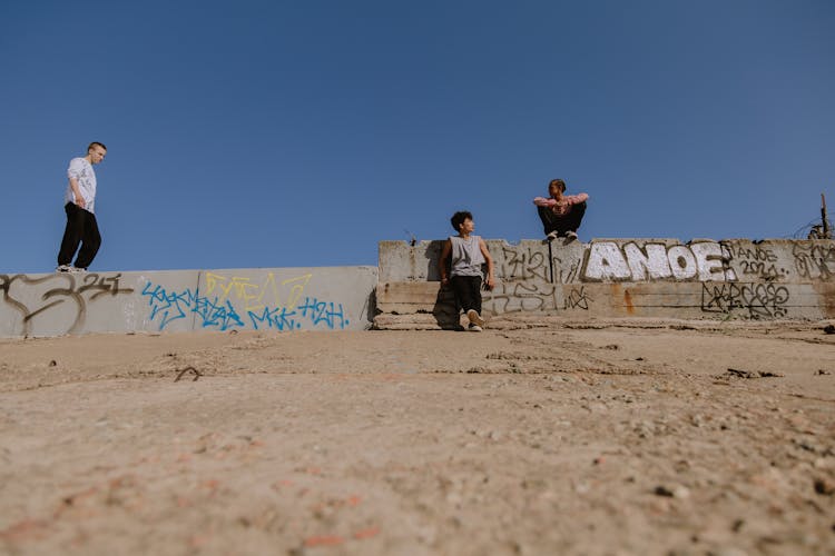 Young Boys Hanging Out Beside A Concrete Fence