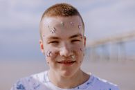 Girl in White Crew Neck Shirt With White Powder on Face