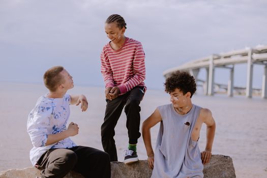 Teens having fun and bonding by the waterfront on a sunny day, showcasing friendship.
