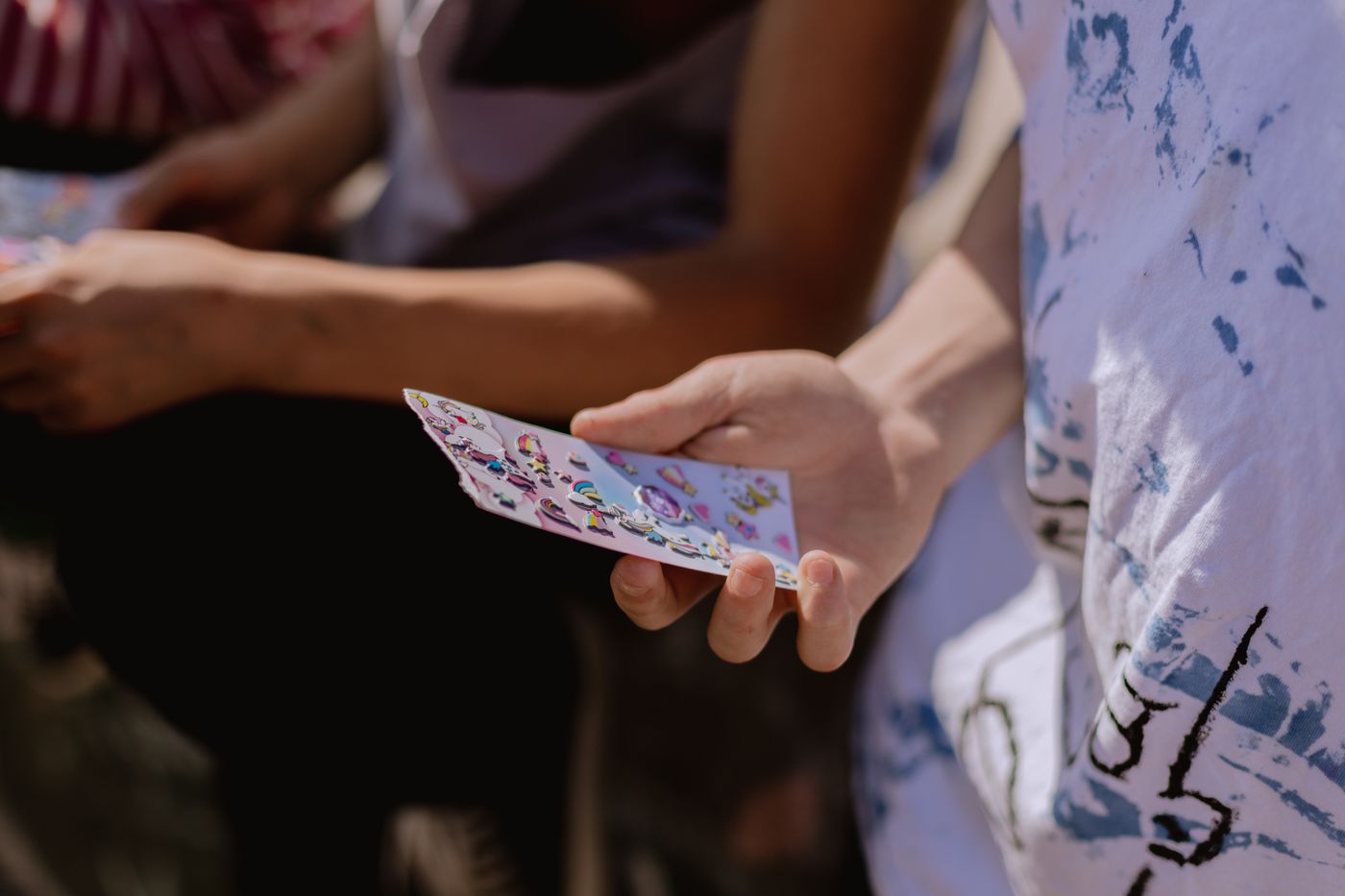 Person holding a printed vinyl sticker sheet outdoors