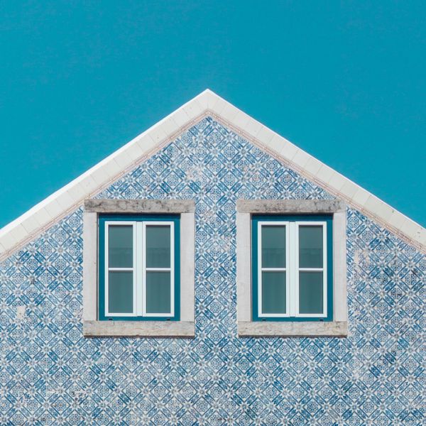 Tiled gable of a Portuguese townhouse against a blue sky — photo by Vlado Paunovic on Pexels