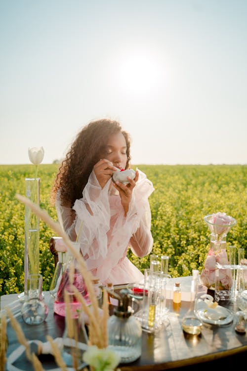 Woman Sitting on a Meadow and Preparing Mixtures