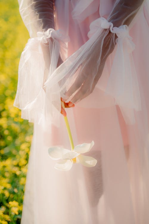 Unrecognizable Woman in Summer Tulle Dress Holding Flower