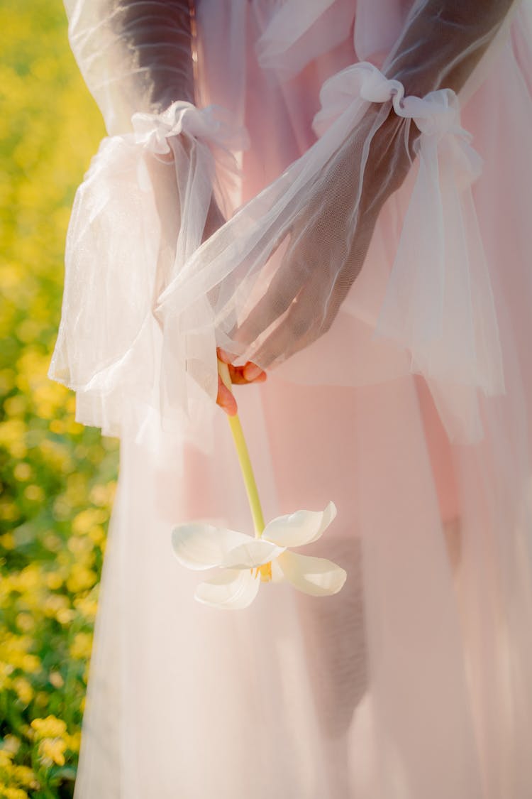 Unrecognizable Woman In Summer Tulle Dress Holding Flower