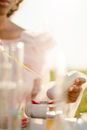 Unrecognizable Woman Adding Oil with Pipette to Mortar with Red Substance