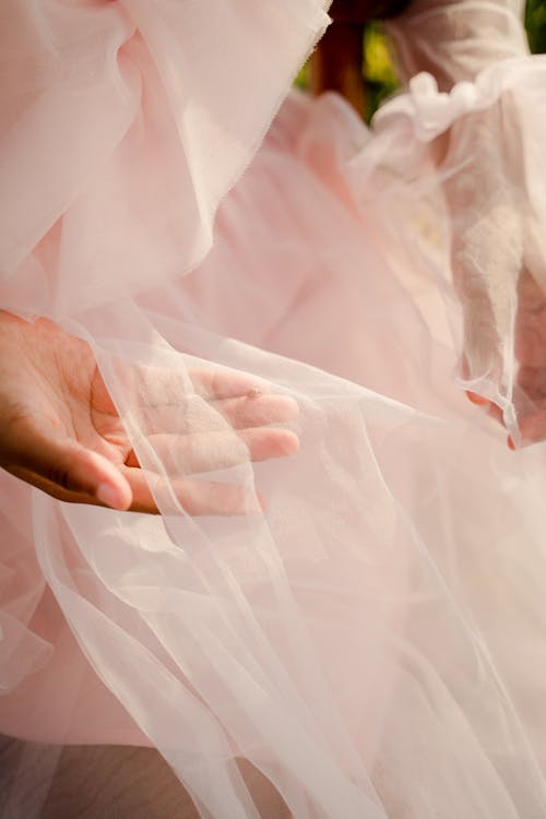 Unrecognizable Female Hands Holding Pink Tulle Fabric of Dress