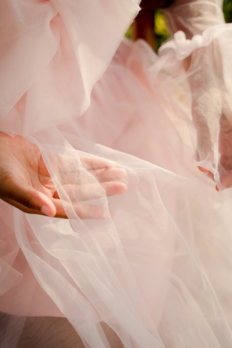 Unrecognizable Female Hands Holding Pink Tulle Fabric Of Dress
