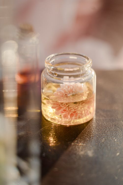 Jar with Flower in Liquid on Table
