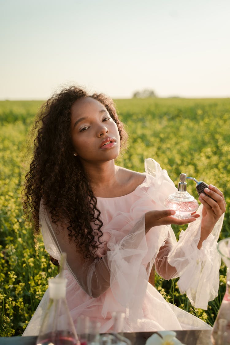 Young Woman Holding Bottle Of Perfume 