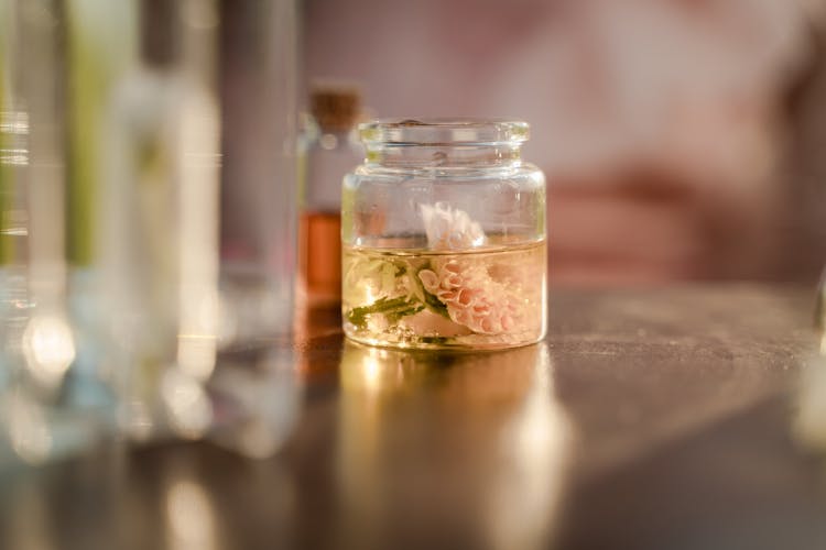 Jar With Flower In Liquid On Table