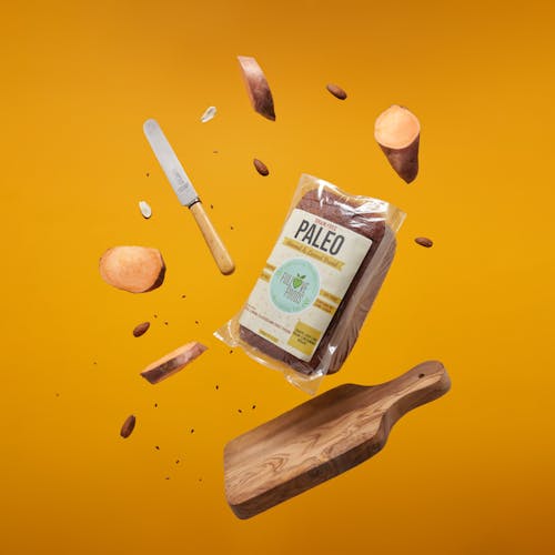 A Shot of Paleo Bread in Bag Surrounded By Cutting Board, Knife and Pieces of Food