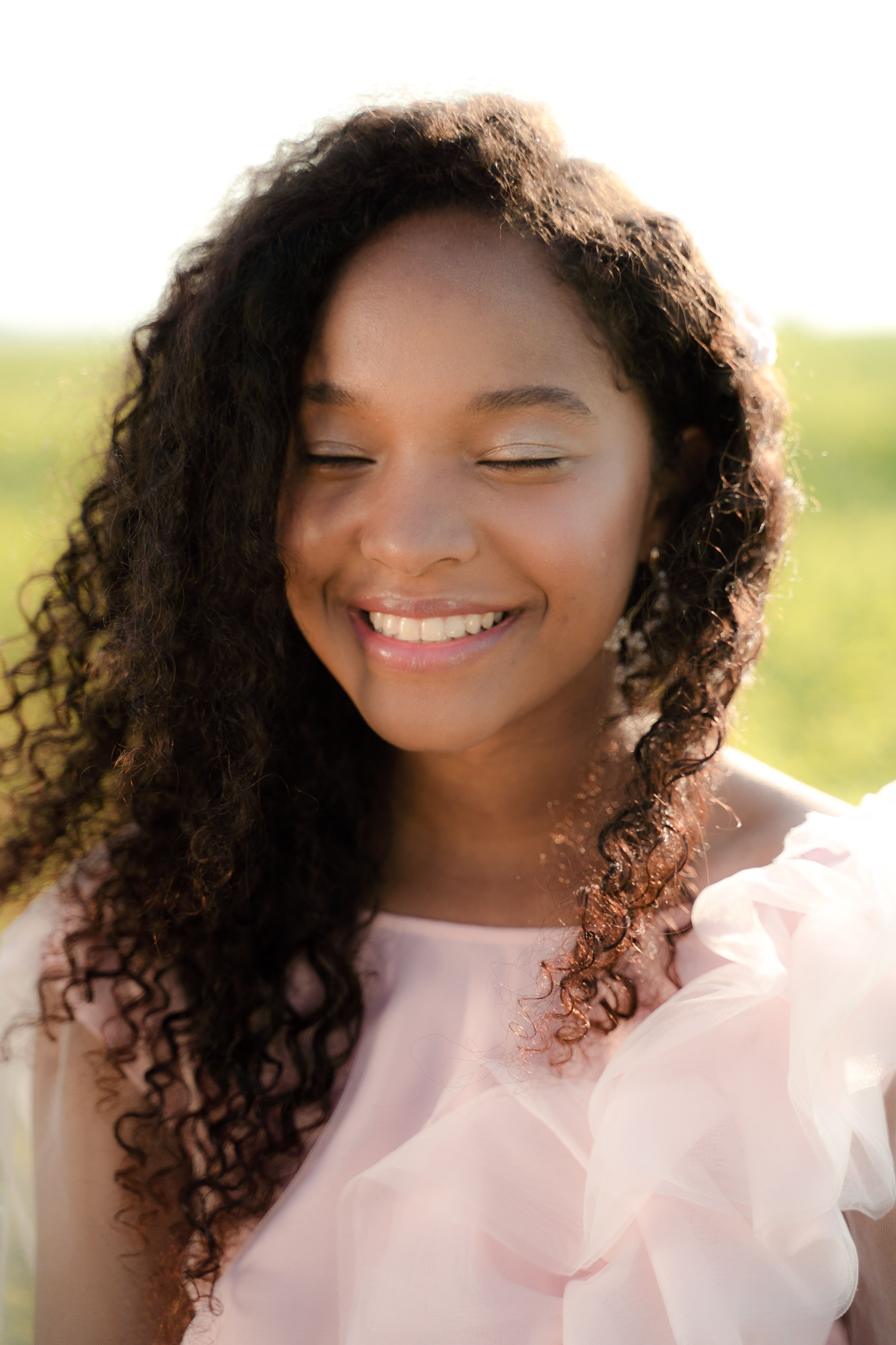 A woman smiling softly in warm natural light