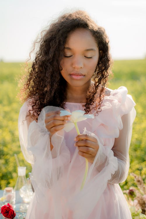 Woman Holding Flower on Flower Meadow 