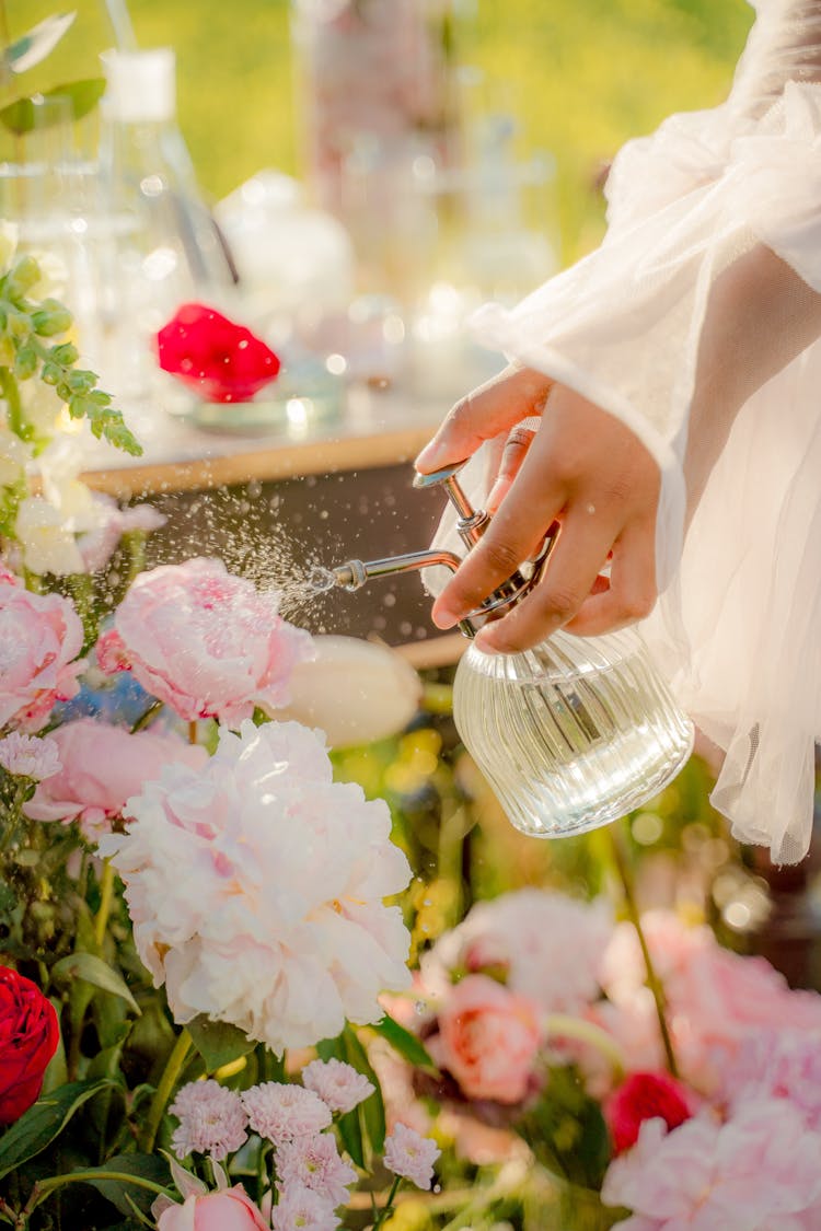 Close-up View Of Spraying Perfume On Flowers