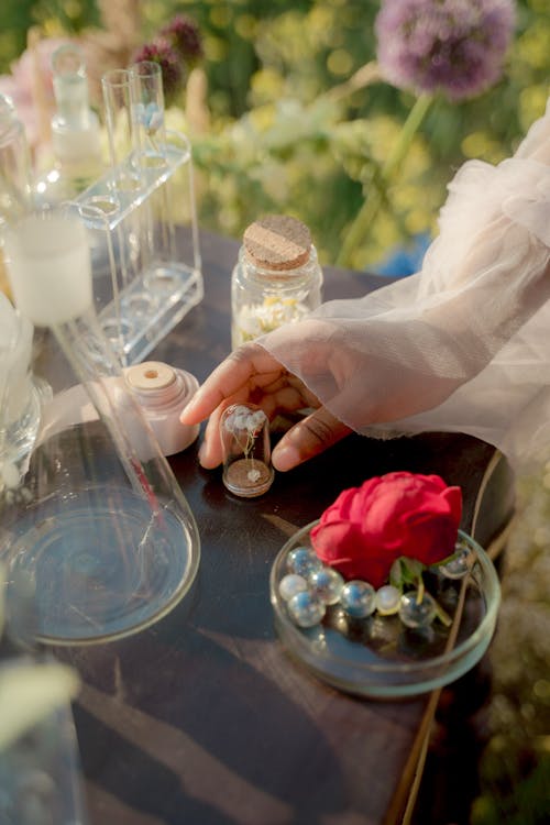 Woman Putting Flowers in Flasks 